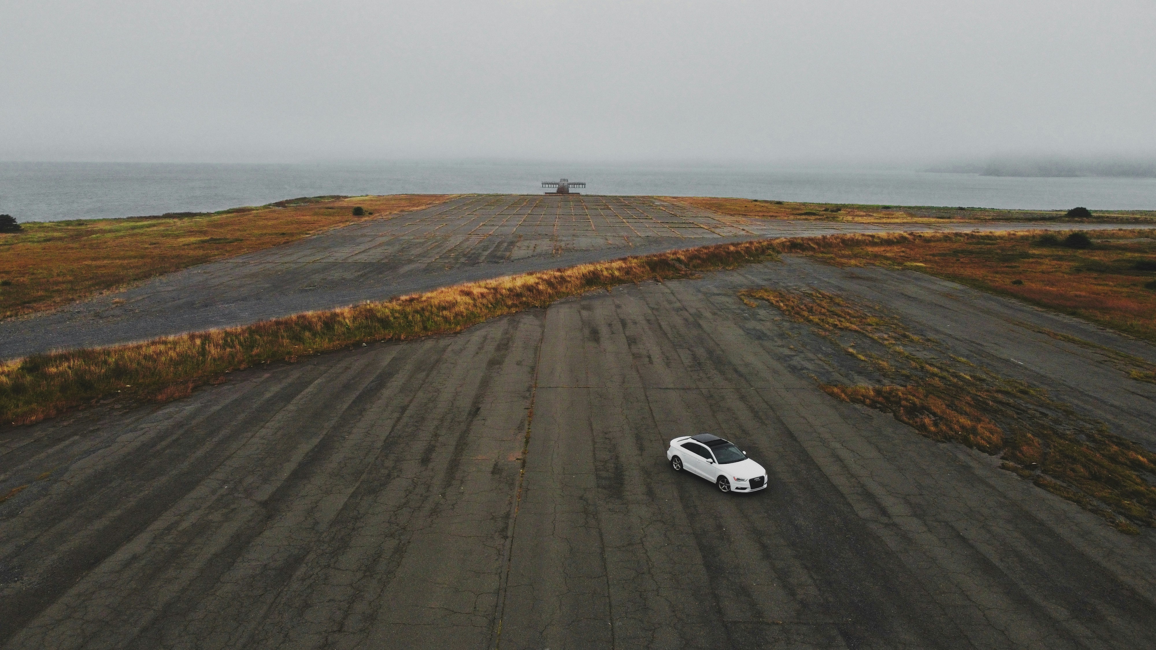 white coupe on gray asphalt road during daytime