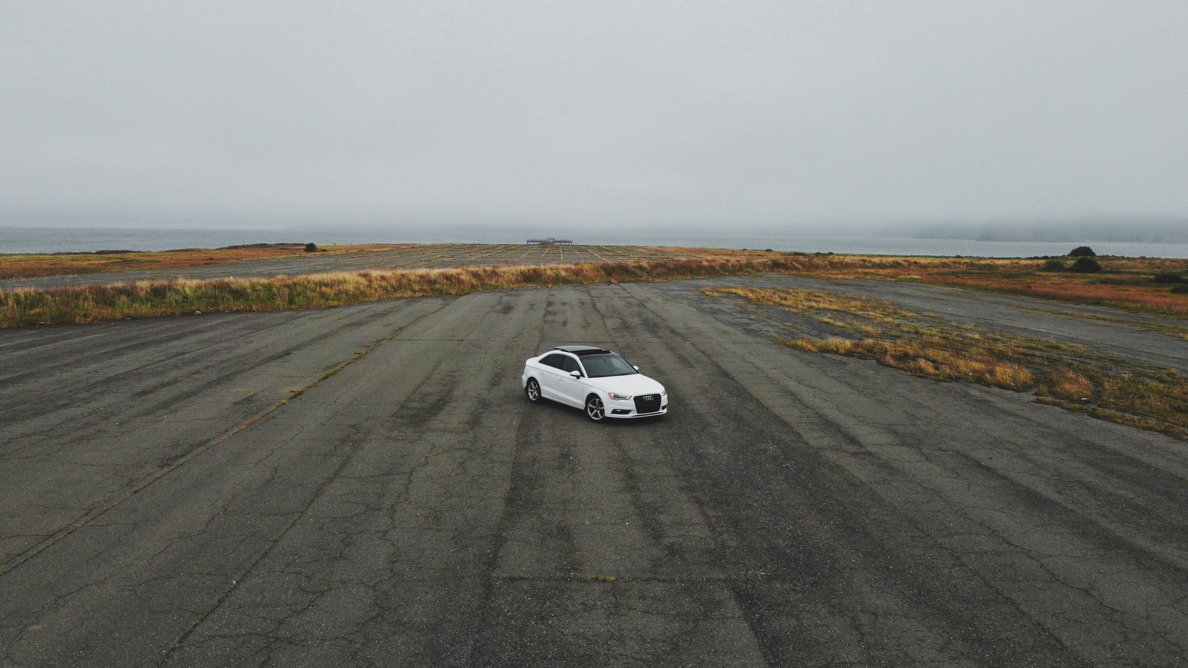 white coupe on gray asphalt road during daytime