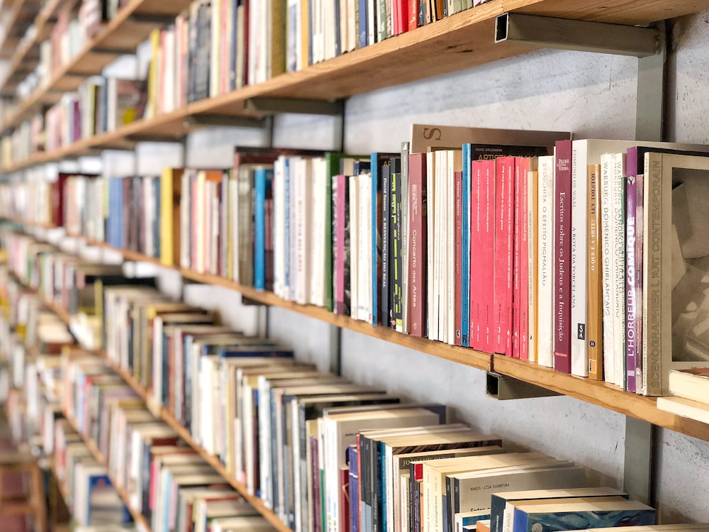 livros na prateleira de madeira marrom