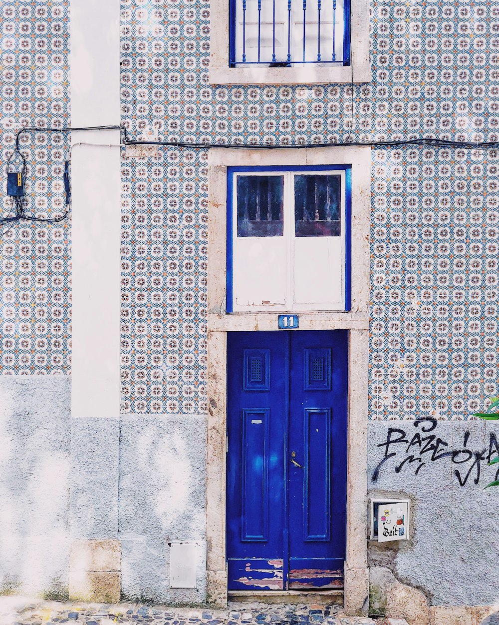 puerta de madera azul sobre pared de hormigón gris