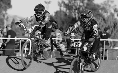 grayscale photo of 2 men riding bicycle