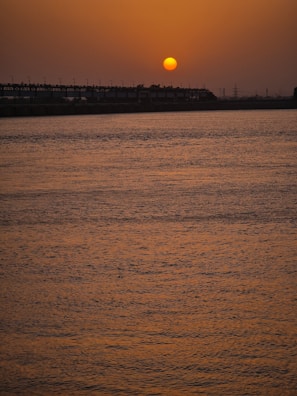 Sunset view over the serene Durgapur Barrage with water reflections.