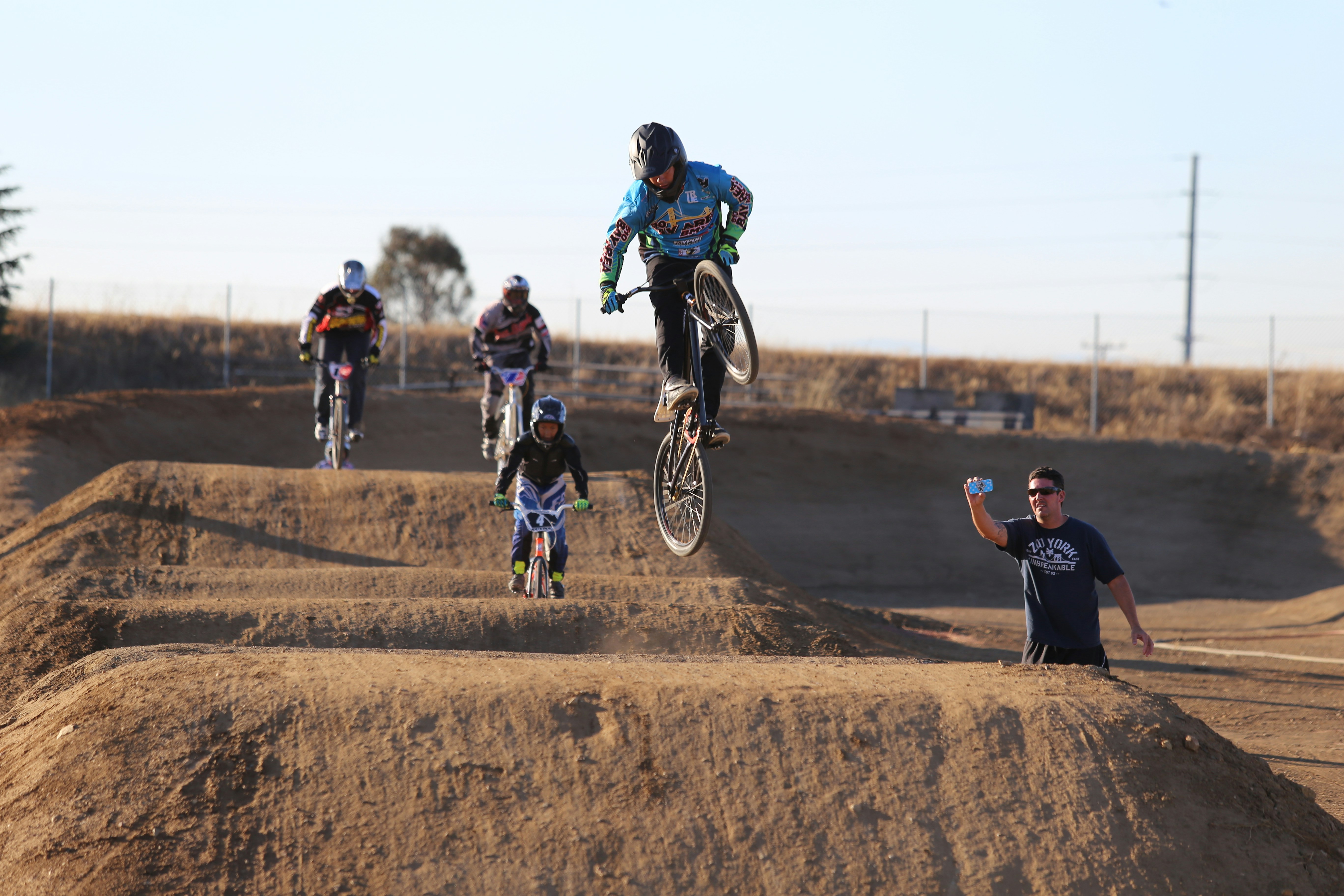 2 men riding bicycle on brown field during daytime