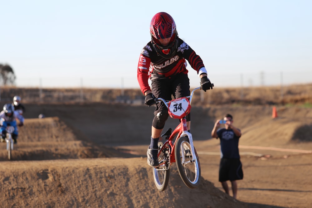 man in black jacket riding red bicycle during daytime