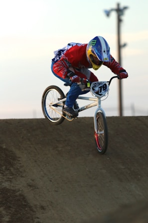Alexandre executing a sharp turn on a BMX race track under dramatic lighting.