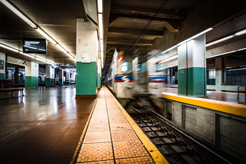 green and yellow train in train station