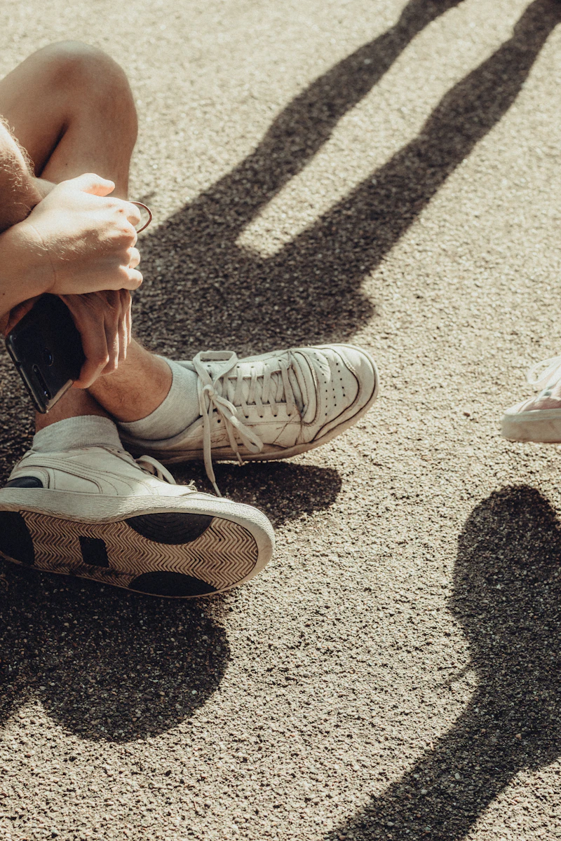 Person tying the laces of white trainers