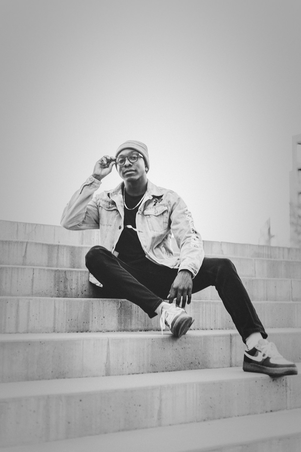 man in white dress shirt and black pants sitting on concrete stairs