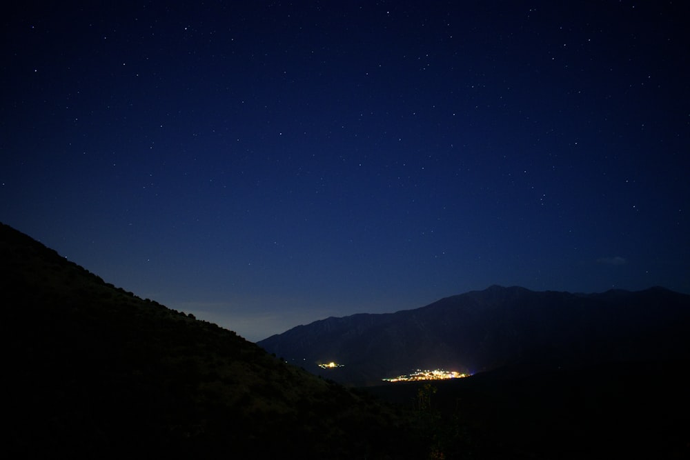 Silueta de la montaña bajo el cielo azul durante la noche