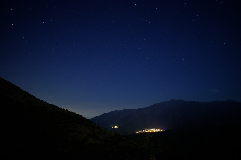 silhouette of mountain under blue sky during night time