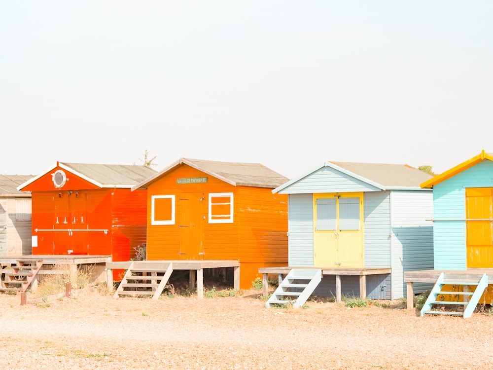 red white and blue wooden houses on brown field under white sky during daytime