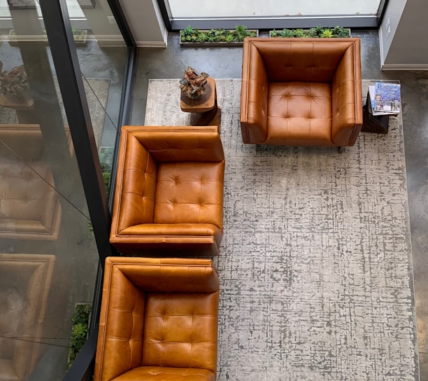 brown leather couch on gray floor