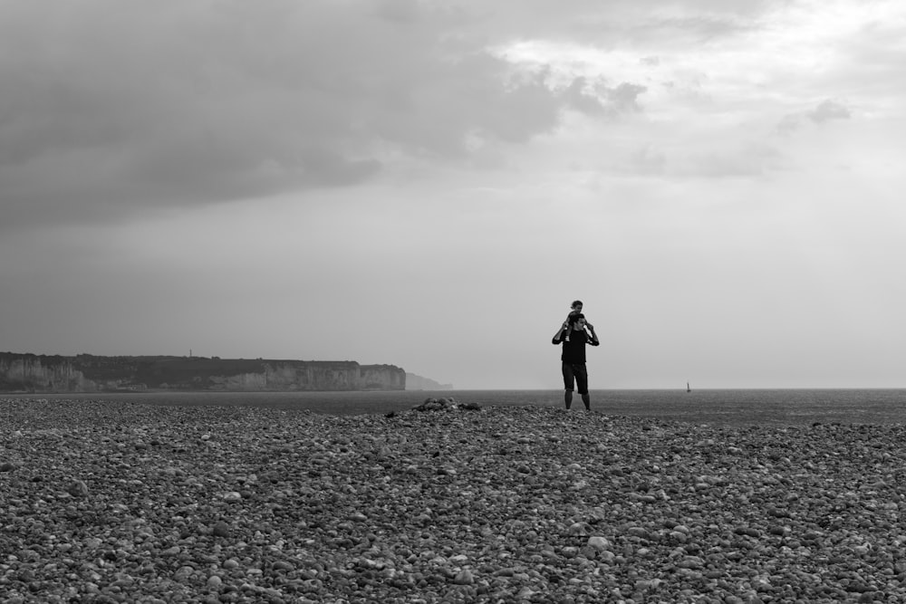 grayscale photo of person standing on the field