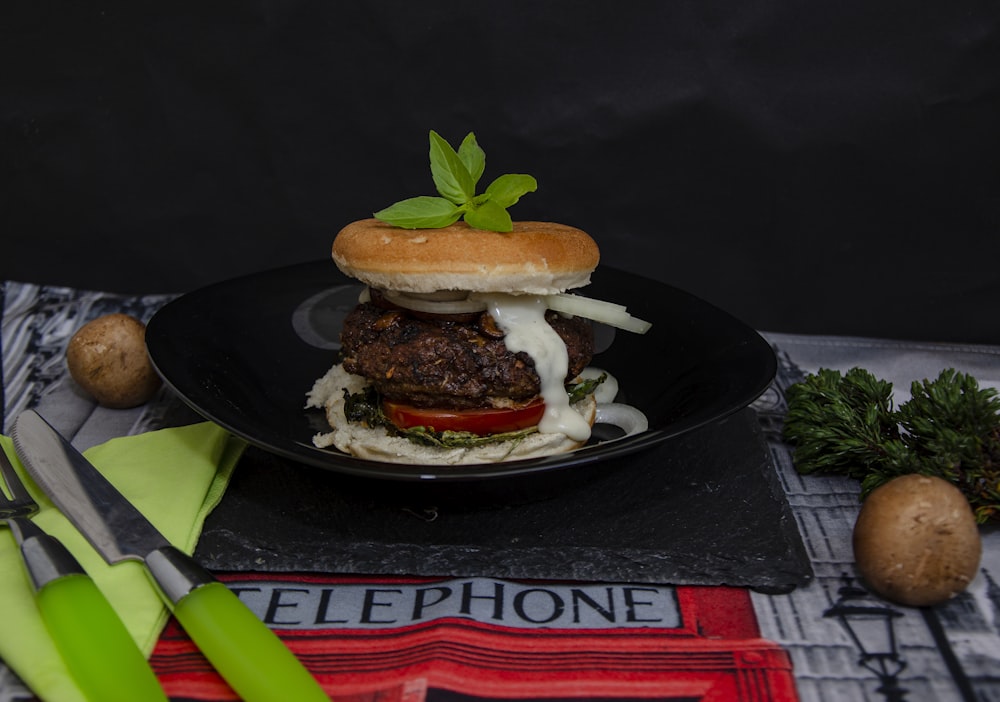 Hamburguesa con lechuga y tomate en plato de cerámica negra