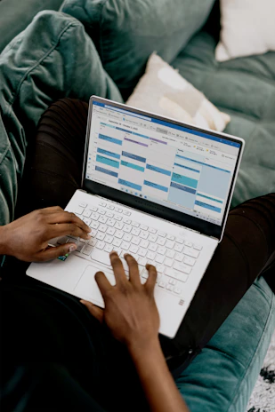 A friendly person checking a calendar on a laptop with country flags around.