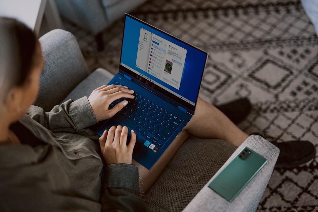 person in brown pants using blue laptop computer