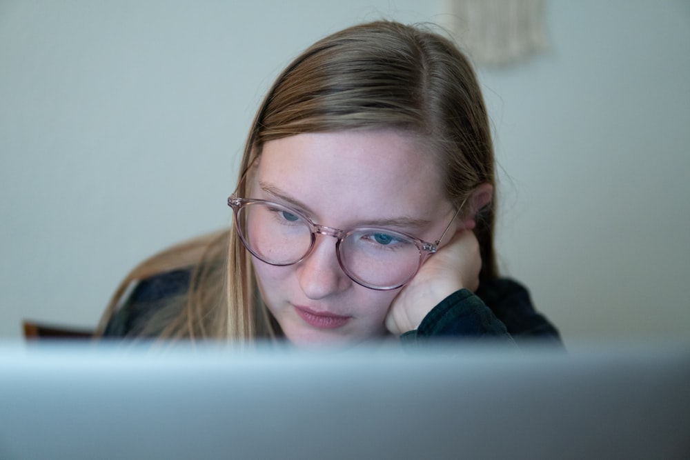 girl in blue jacket wearing brown framed eyeglasses