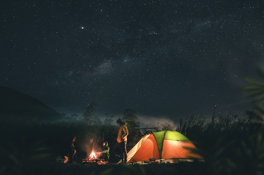 man in green and yellow tent under starry night