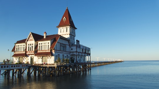 white and brown concrete building beside body of water during daytime in Club de Pescadores Argentina