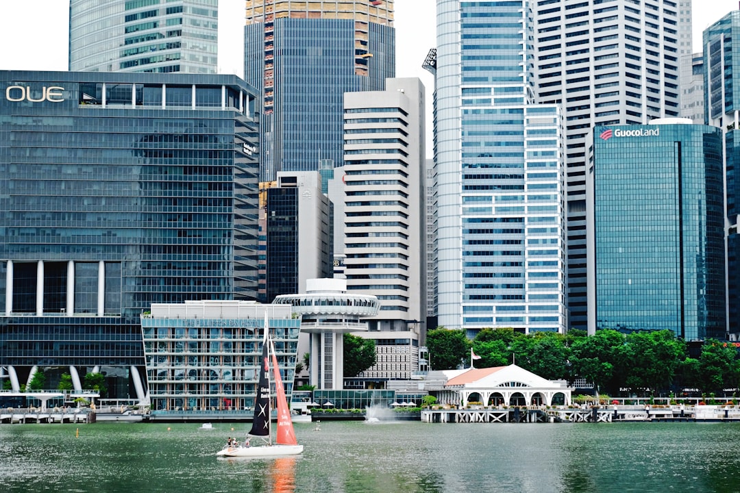 red and white sailboat on water near city buildings during daytime