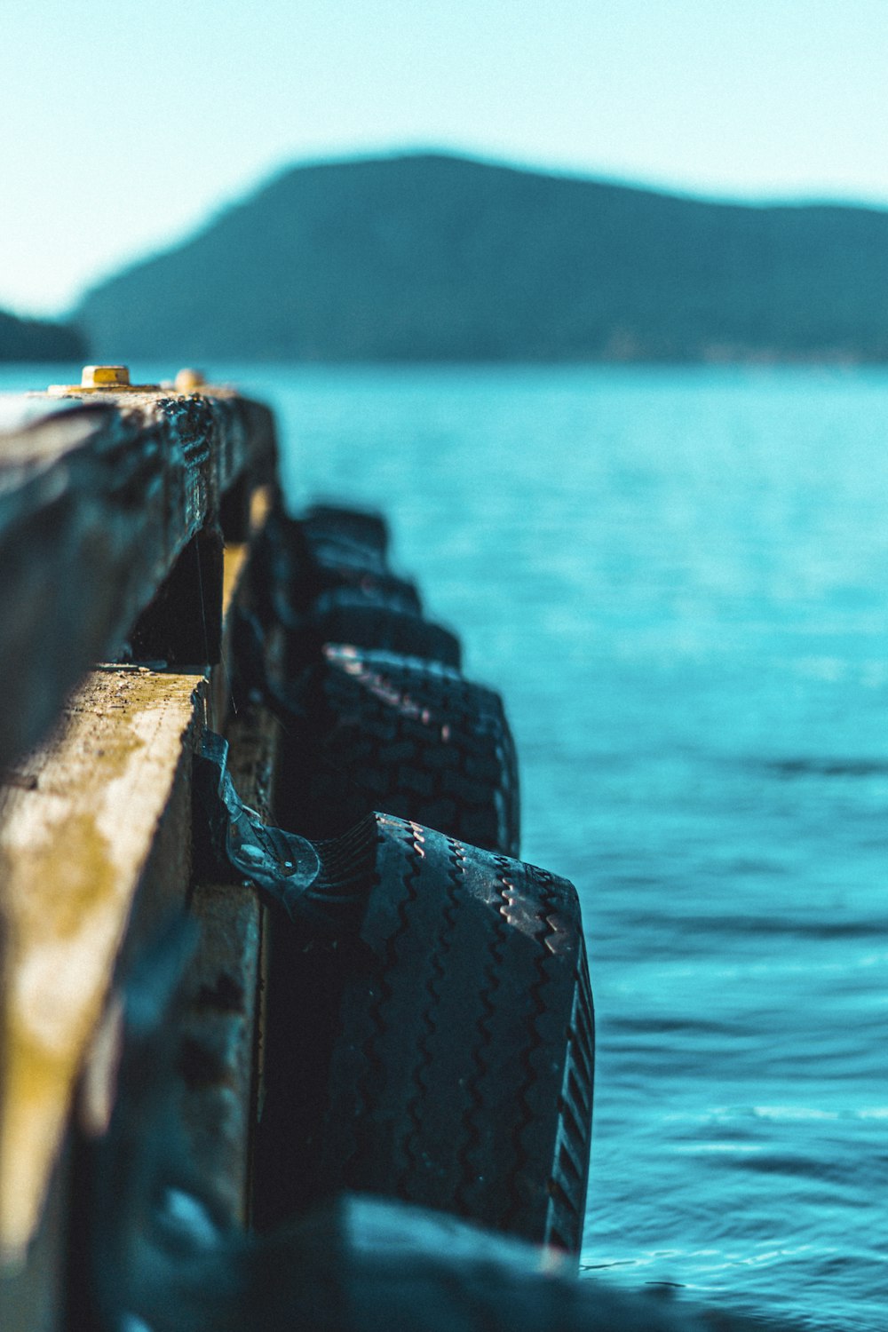 brown wooden fence near body of water during daytime