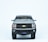 A miniature model of a black Chevrolet truck is displayed with a focus on the front grille and the distinctive yellow Chevrolet logo. The details include the headlights and a small license plate with indistinct text.