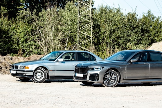 black bmw coupe parked beside gray metal tower during daytime