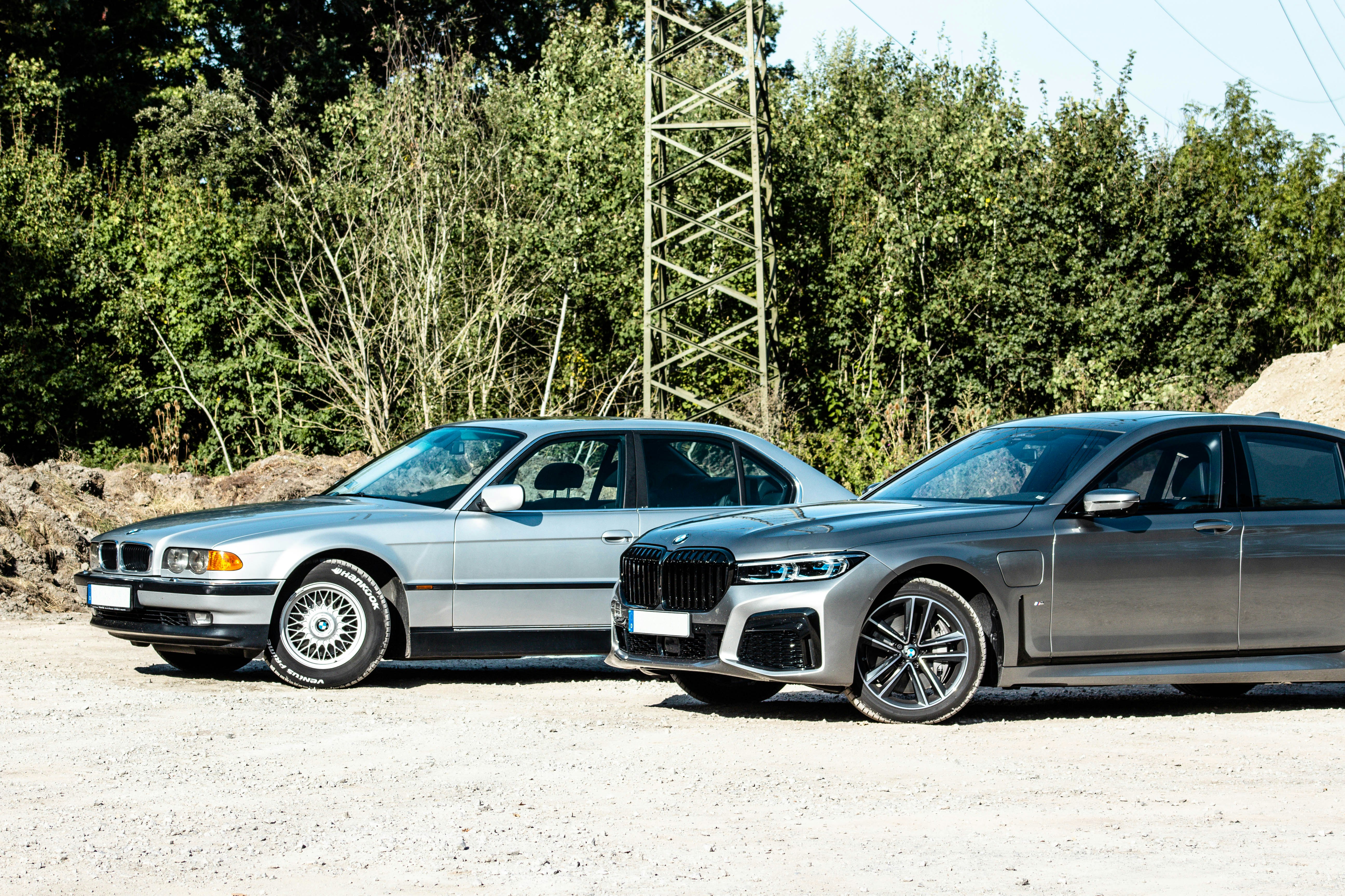 black bmw coupe parked beside gray metal tower during daytime