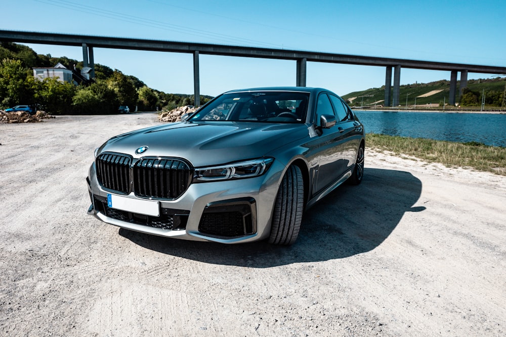 blue bmw m 3 coupe parked on gray sand during daytime