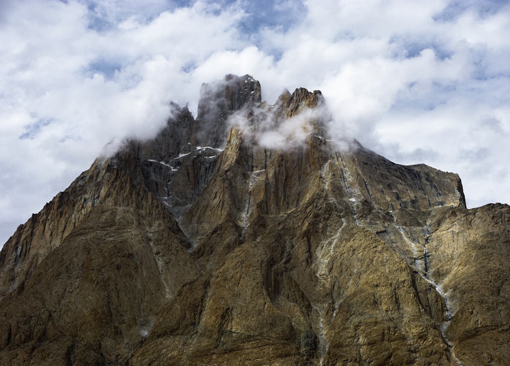 montanha marrom e cinza sob nuvens brancas durante o dia