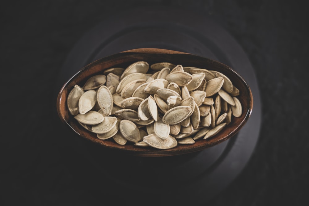 brown and white nuts on brown ceramic bowl