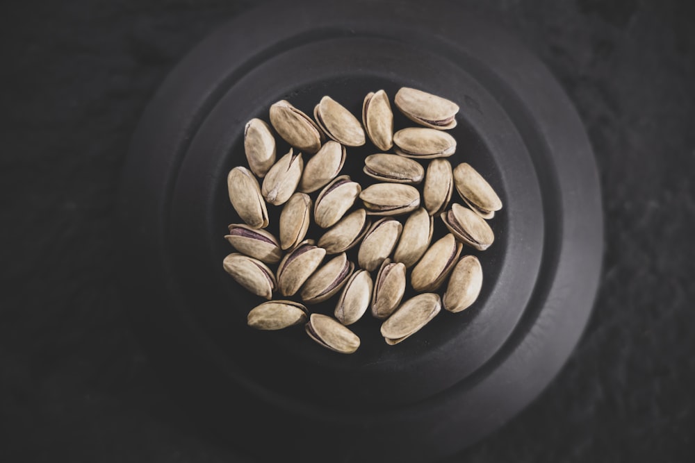 brown coffee beans on black ceramic plate