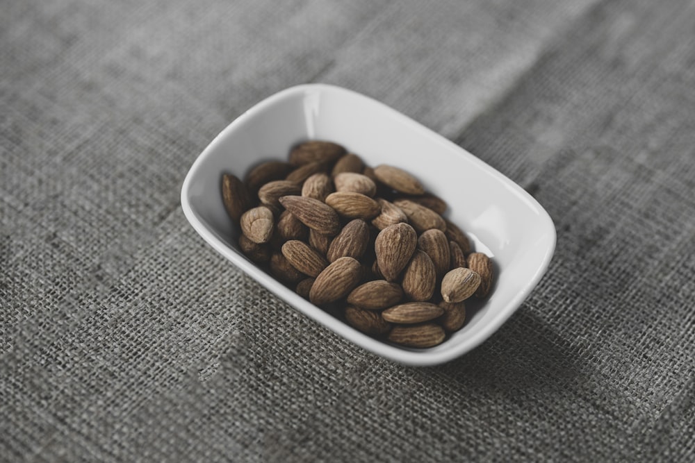 brown coffee beans on white ceramic bowl