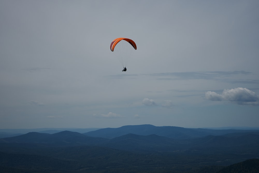 person in parachute over the clouds