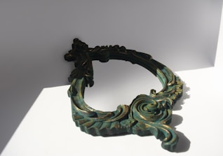 Elegant black and gold frame resting on a sleek ivory surface with soft shadows.