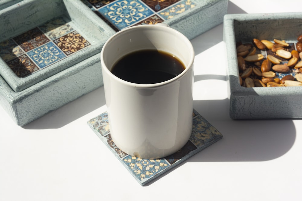 Taza de cerámica blanca sobre mesa blanca