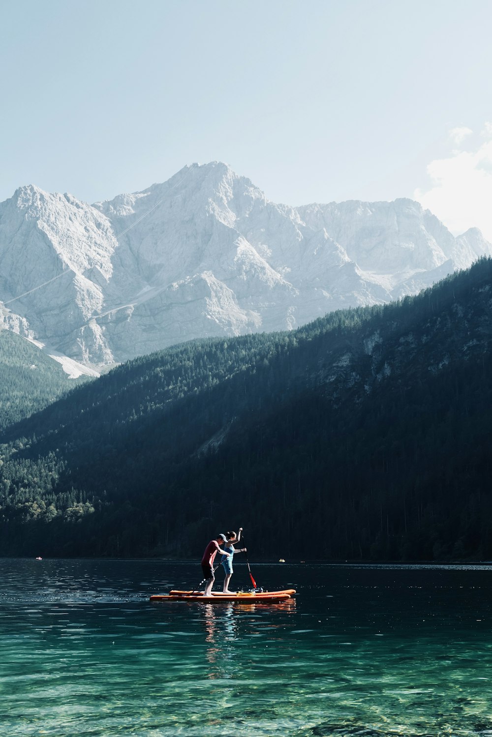 man in red shirt riding on boat on lake during daytime