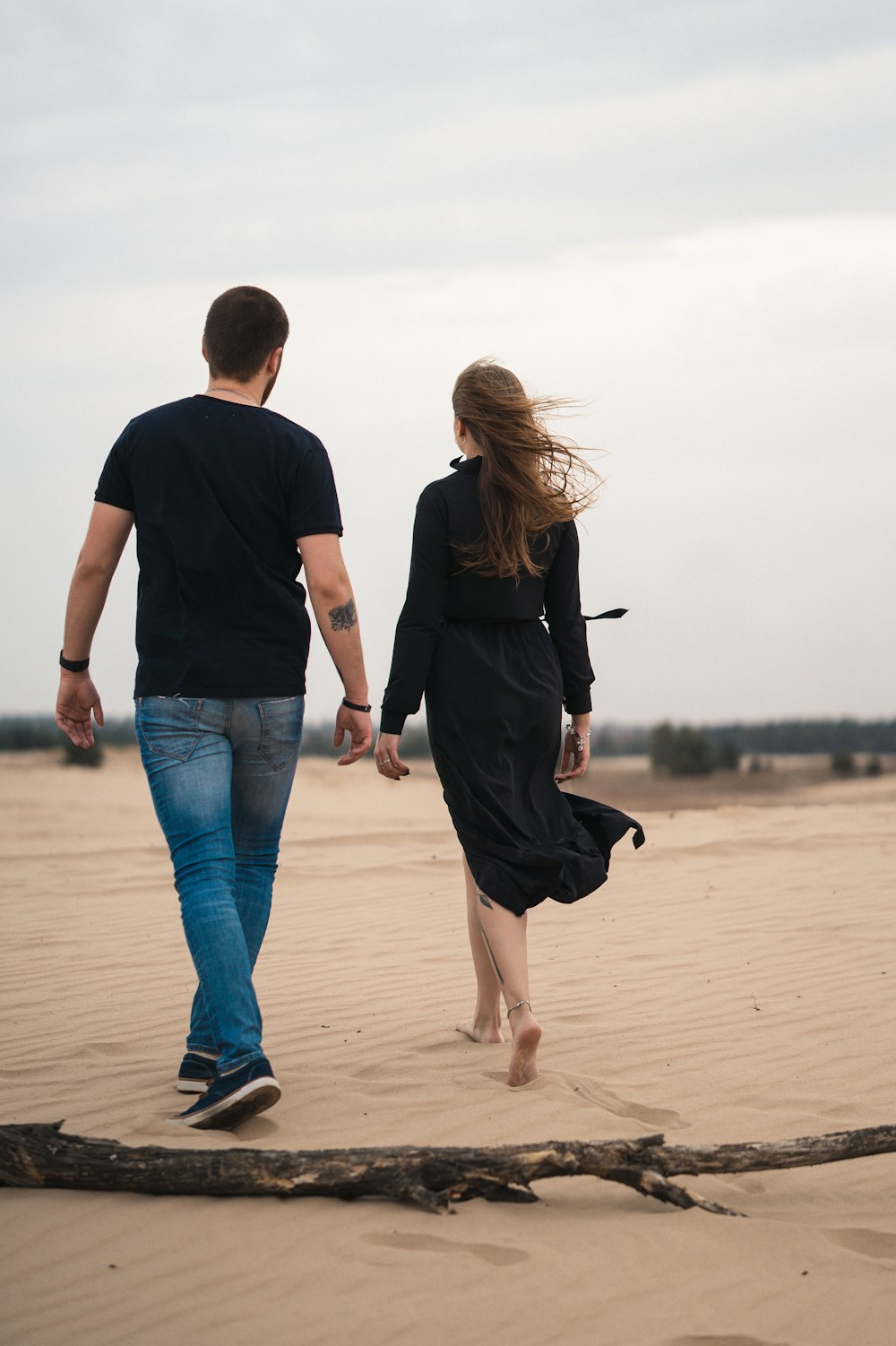 man and woman walking on beach during daytime