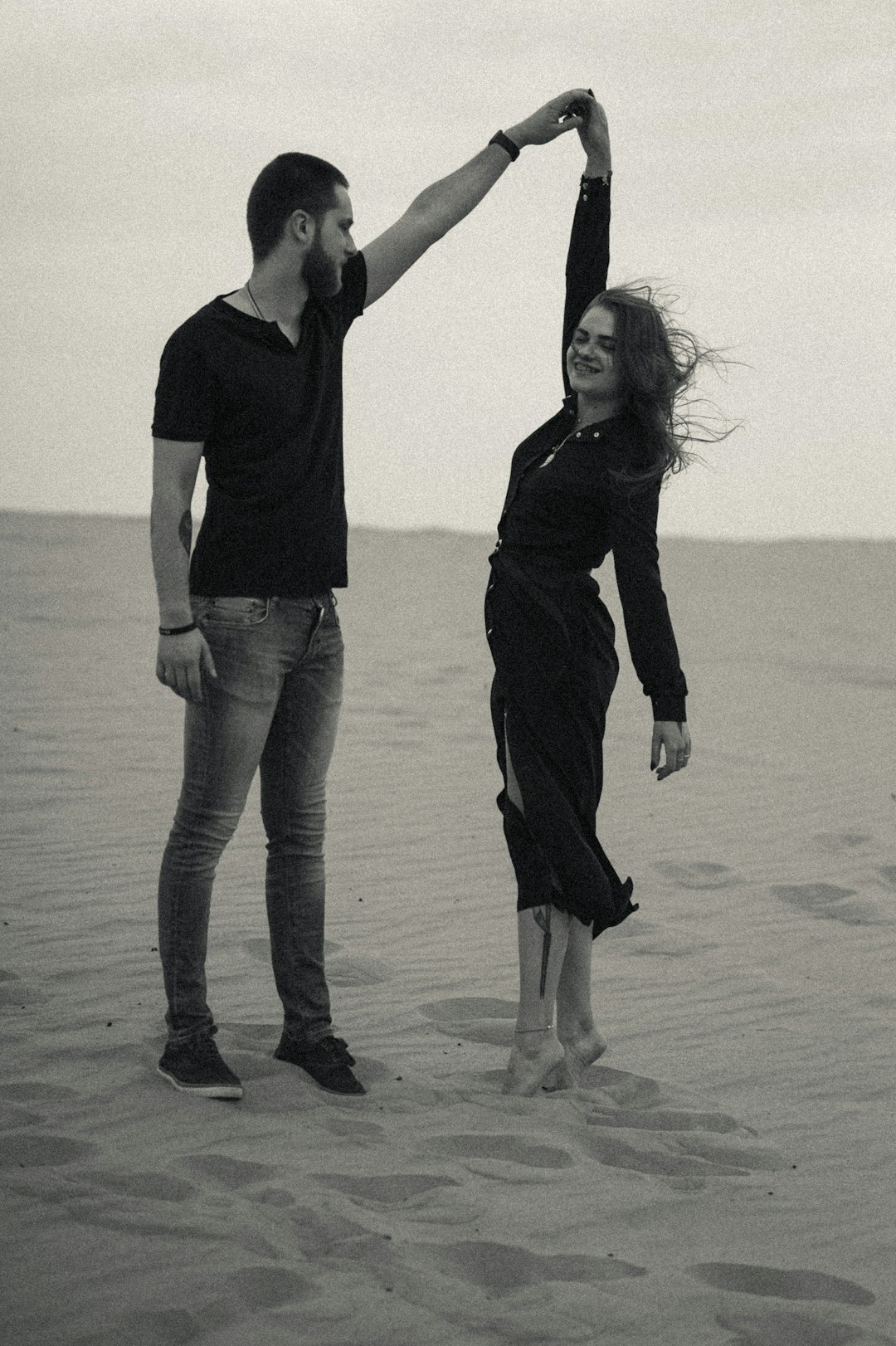 man and woman holding hands on beach