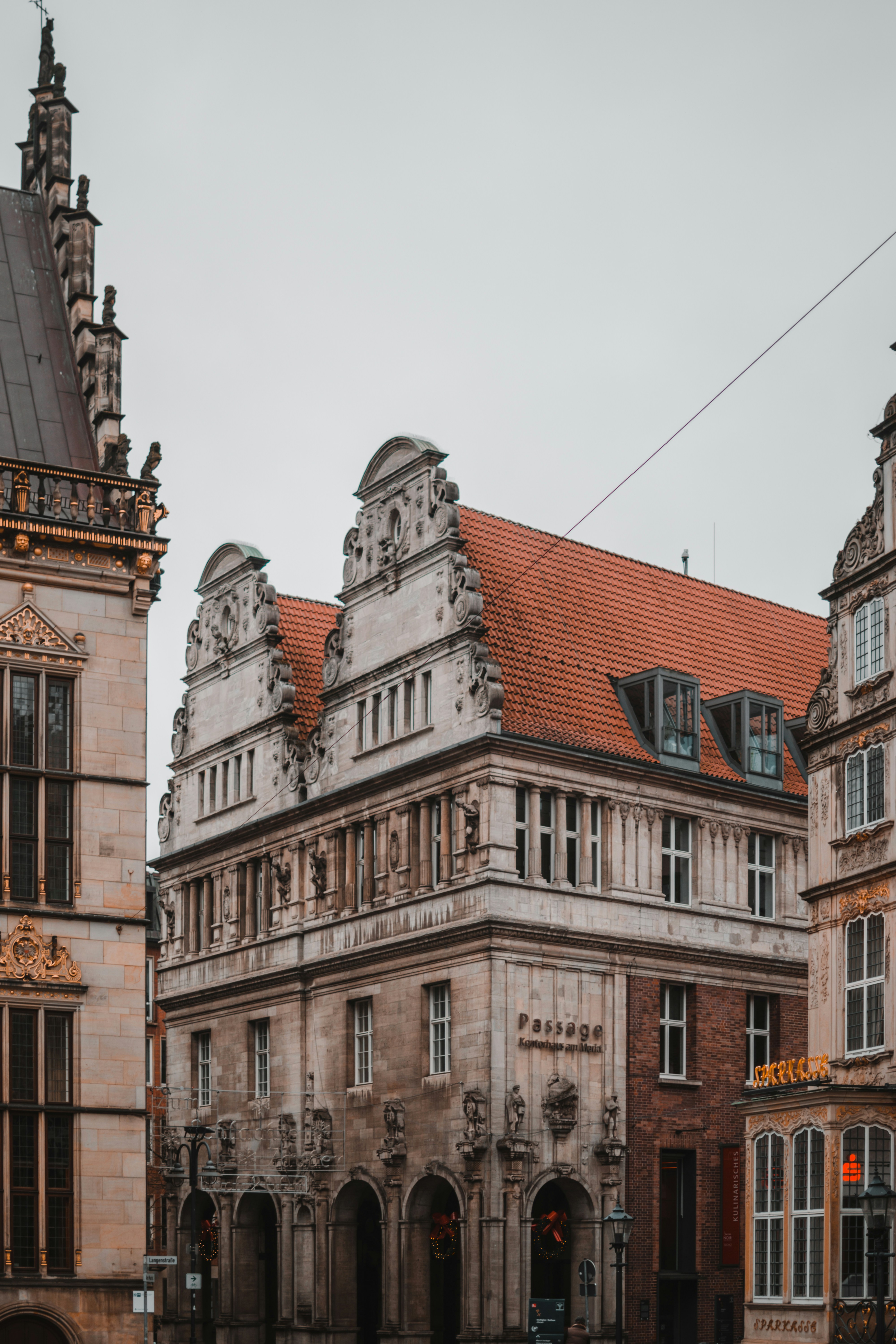 edificio in cemento marrone sotto il cielo bianco durante il giorno