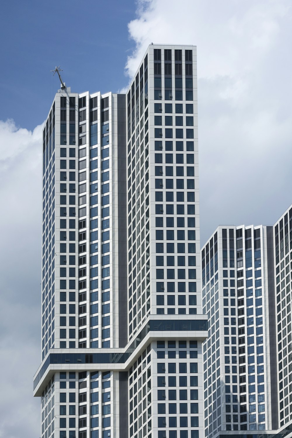 white and black concrete building under white clouds during daytime