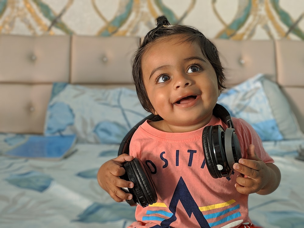 a little girl with headphones in her hands
