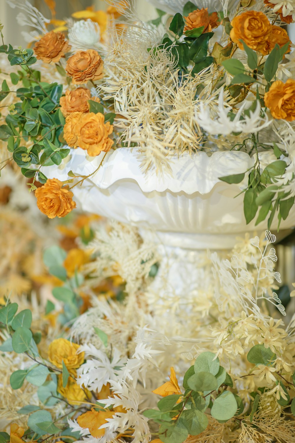 orange and white flowers in white ceramic vase