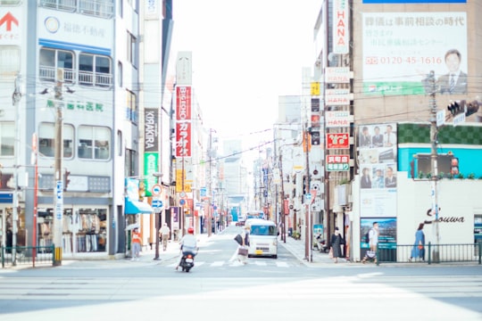 cars on road between buildings during daytime in Nagasaki Japan