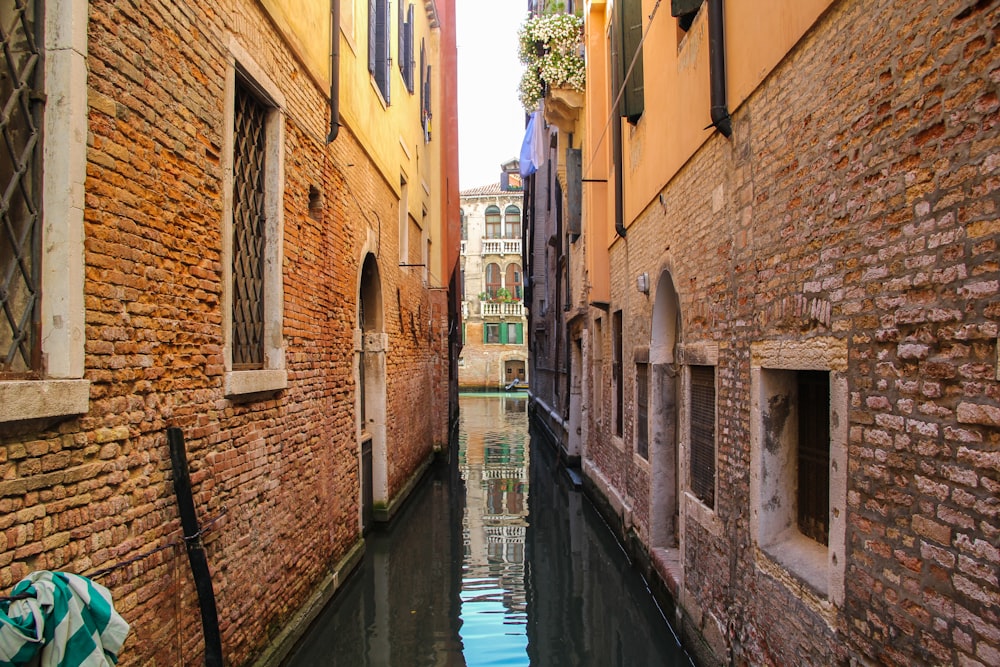 river between brown brick buildings during daytime