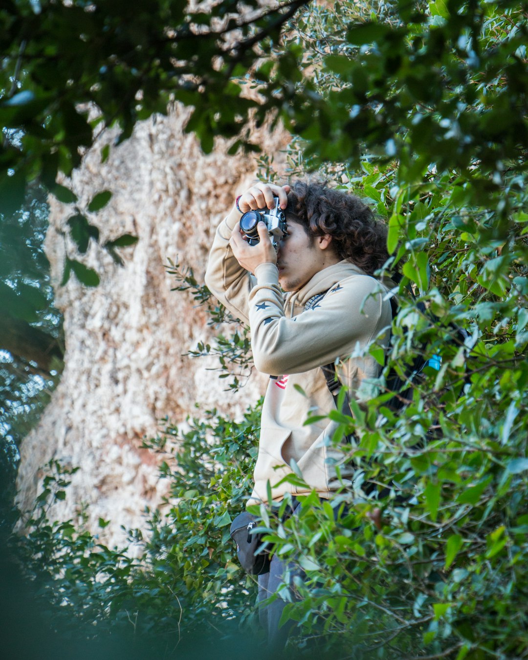 woman in beige coat taking photo of green plants