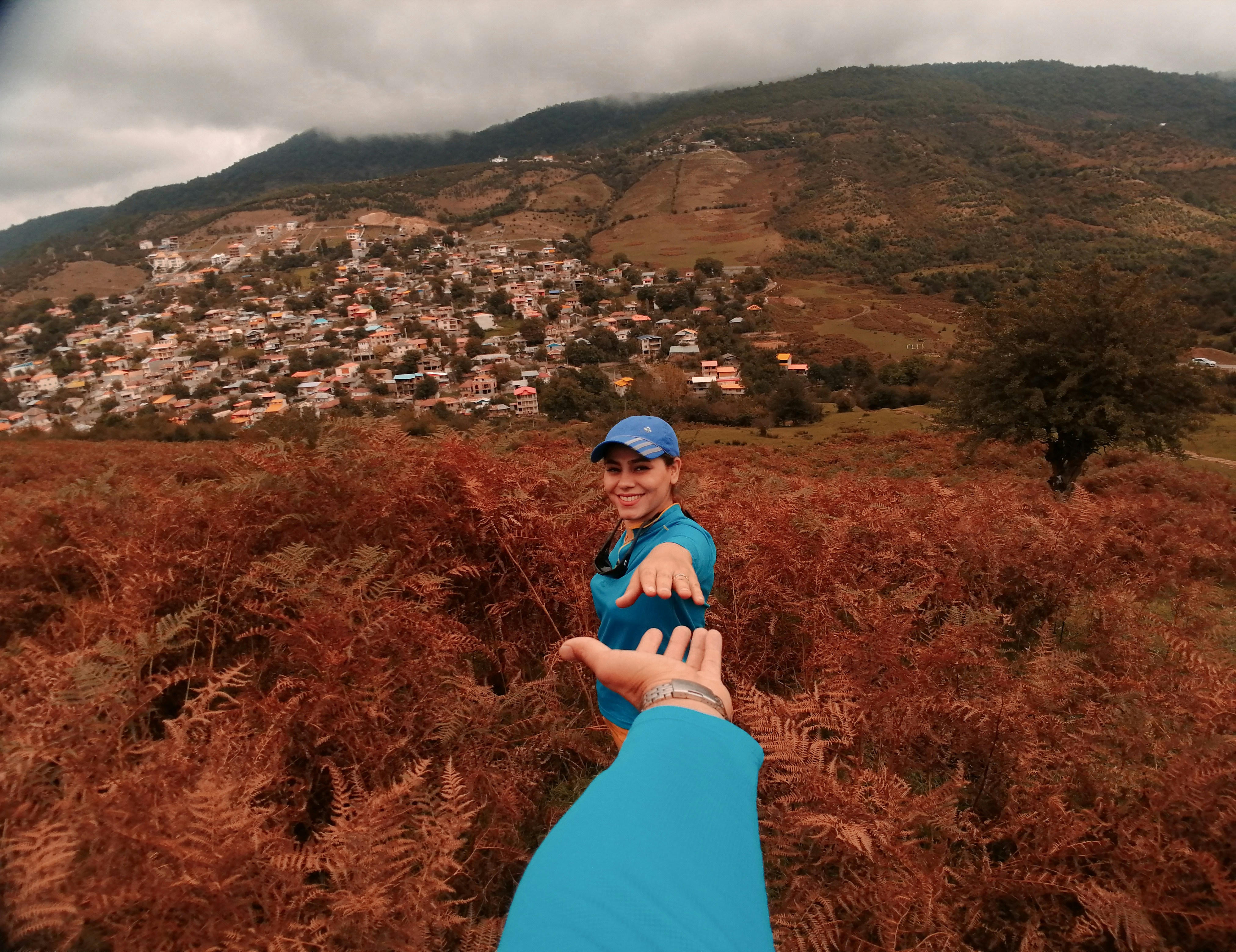 woman in blue dress standing on brown grass field during daytime