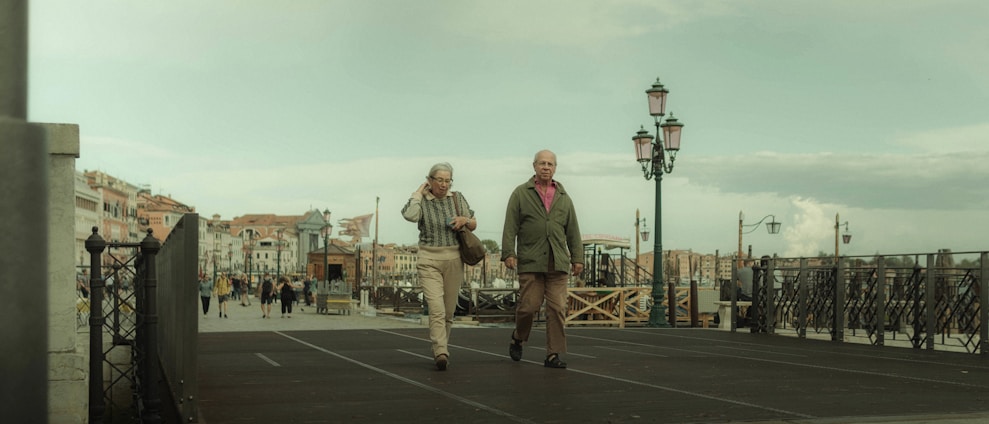 A cheerful senior couple walking near the Golden Gate Bridge with Marin County hills in the background.