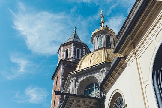 brown and white concrete building under blue sky during daytime in Wawel Royal Castle Poland