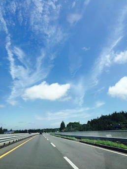 A clean, well-maintained road stretching into the distance under a bright blue sky, symbolizing road hygiene.
